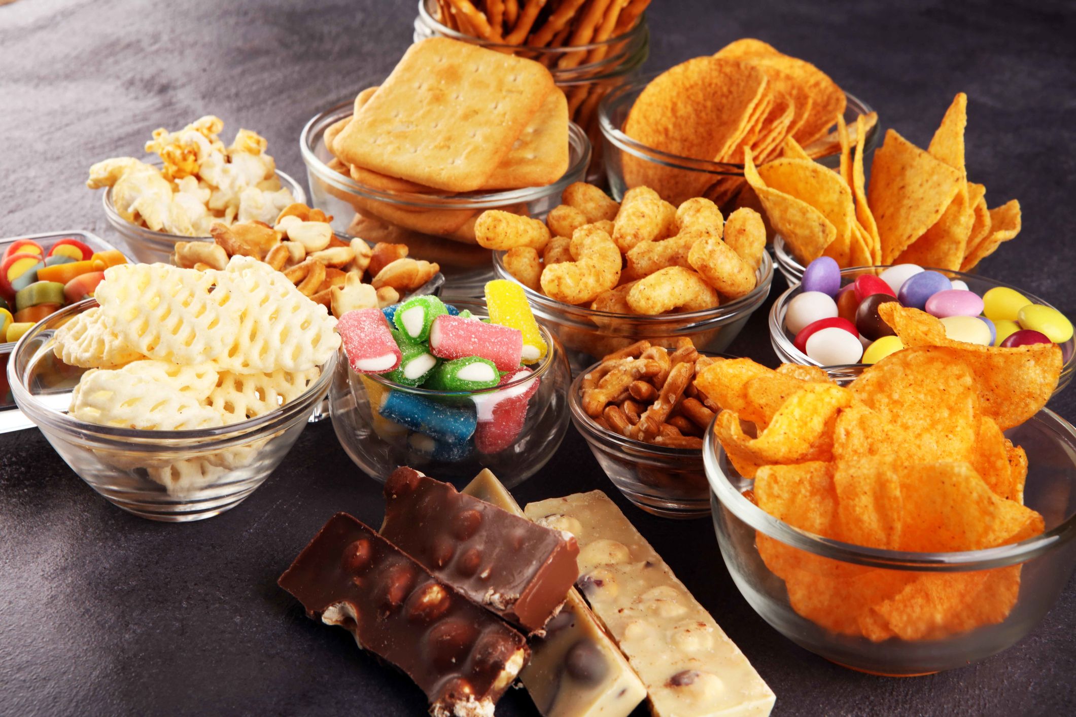 Salty snacks, pretzels, chips, crackers in glass bowls